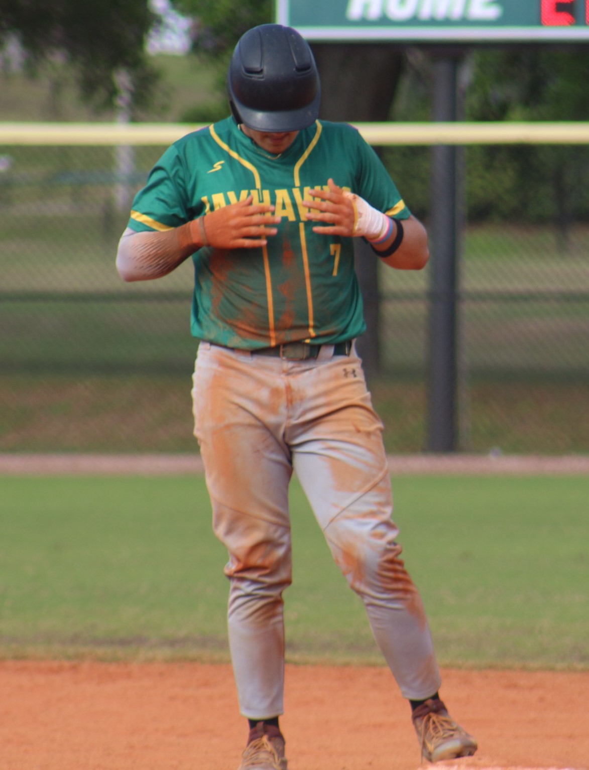 Jackson Shannon brushes dirt of his jersey after reaching second base